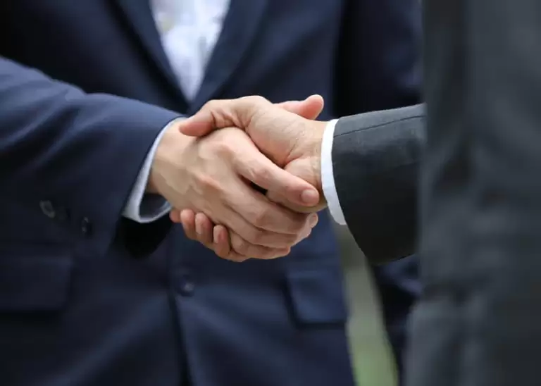 two attorneys in business suits shaking hands